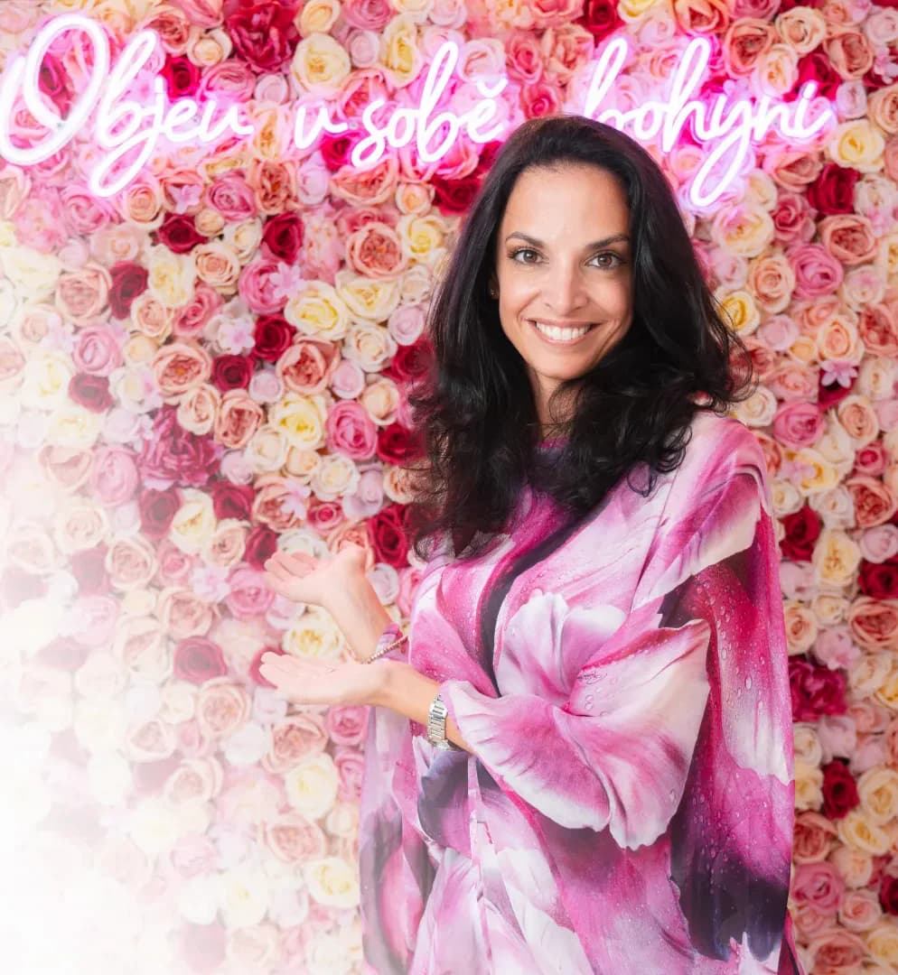 Michaela Brosche, zakladatelka Deadia Cosmetics, před stěnou z růží s neonovým nápisem Objev v sobě bohyni